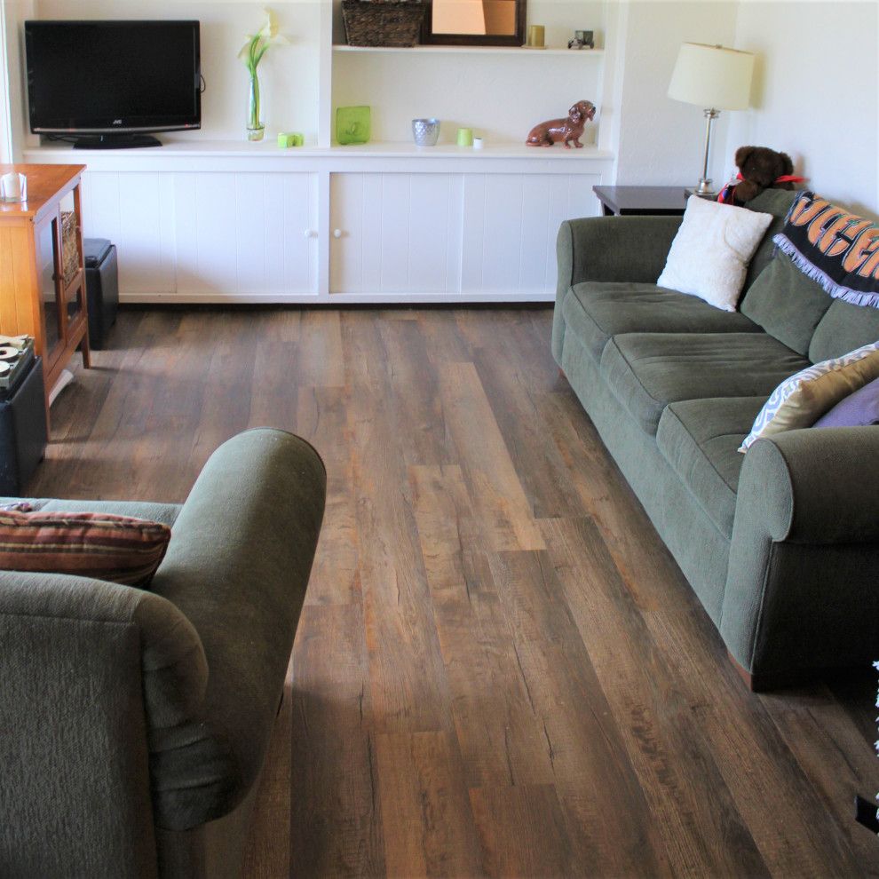 На фото: гостиная комната с белыми стенами, полом из винила и коричневым полом