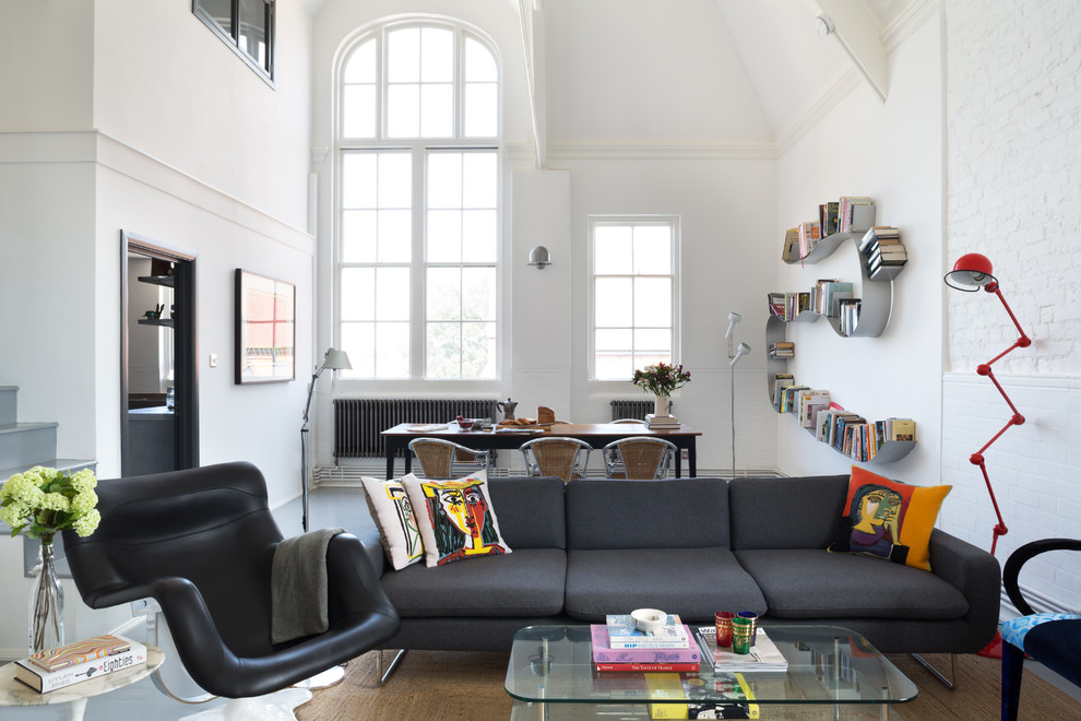 Photo of an urban open plan living room in London with a reading nook, white walls, concrete flooring and no fireplace.