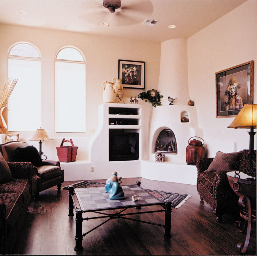 Exemple d'un grand salon méditerranéen ouvert avec une salle de réception, un mur beige, parquet foncé, un poêle à bois, un manteau de cheminée en plâtre et un téléviseur encastré.