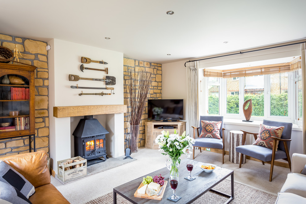 Inspiration for a mid-sized country formal and enclosed carpeted living room remodel in Gloucestershire with white walls, a wood stove, a plaster fireplace and a tv stand