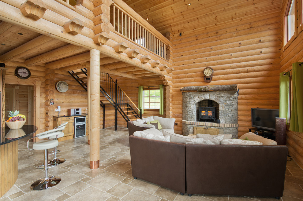 Exemple d'un salon montagne de taille moyenne et ouvert avec un mur marron, un sol en ardoise, un poêle à bois, un manteau de cheminée en bois et un téléviseur indépendant.