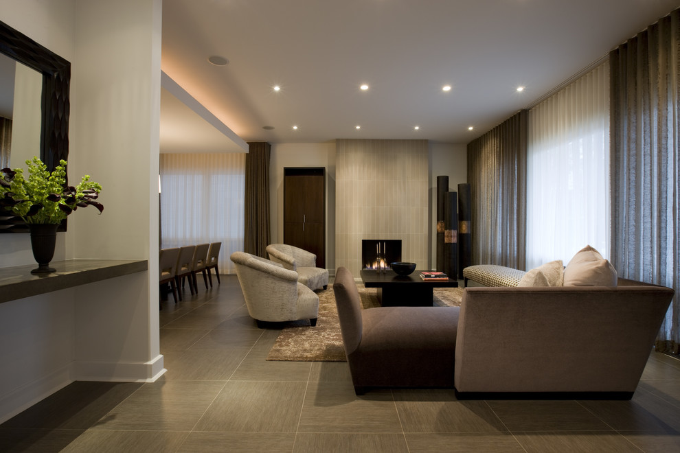 Immagine di un soggiorno design con cornice del camino piastrellata, pavimento in gres porcellanato e tappeto
