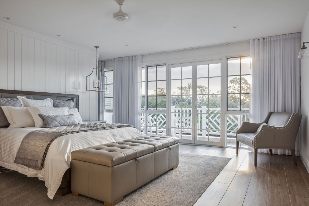 Maritimes Schlafzimmer mit weißer Wandfarbe, braunem Holzboden und braunem Boden in Gold Coast - Tweed