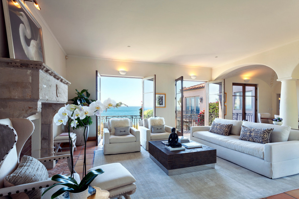 Großes, Offenes Mediterranes Wohnzimmer mit Kamin, orangem Boden und gewölbter Decke in Los Angeles