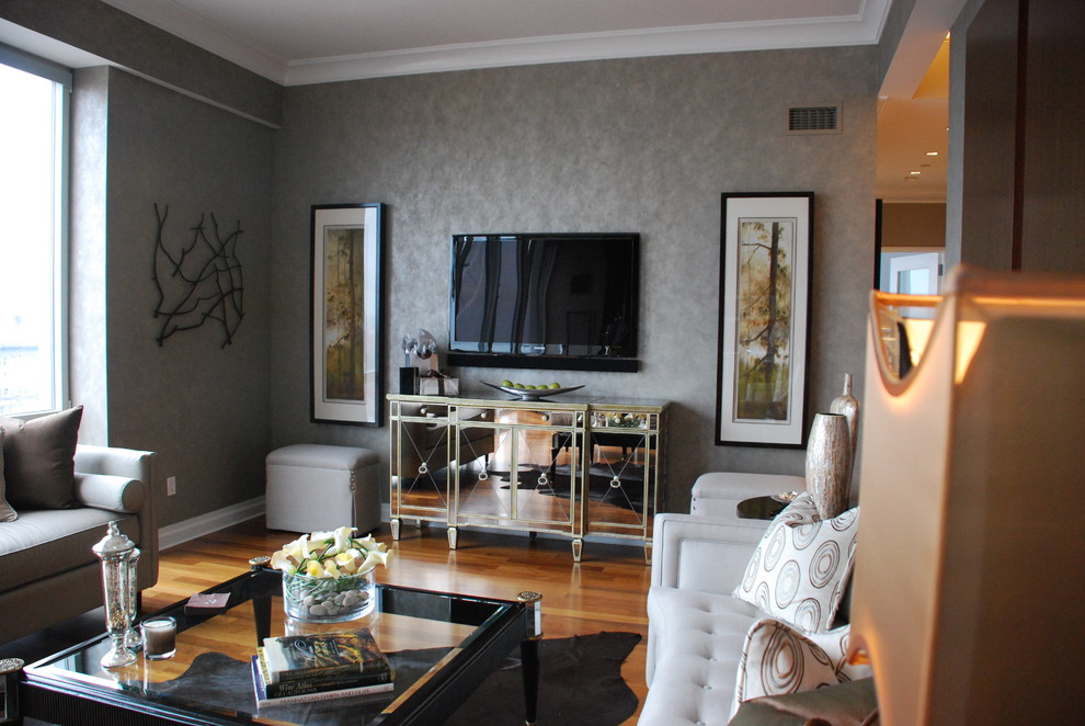 Идея дизайна: изолированная гостиная комната среднего размера в стиле модернизм с серыми стенами, паркетным полом среднего тона и телевизором на стене
