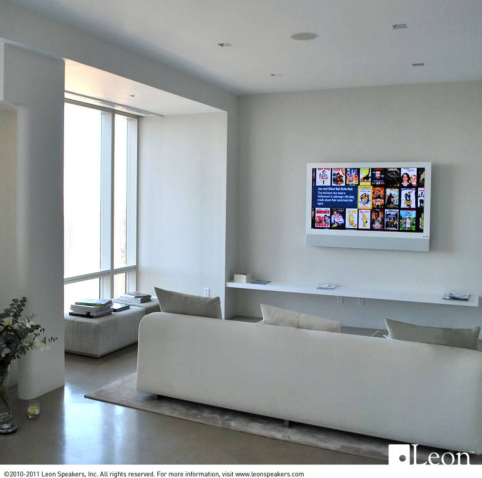 Imagen de salón cerrado contemporáneo pequeño sin chimenea con paredes blancas, suelo de madera en tonos medios y televisor colgado en la pared