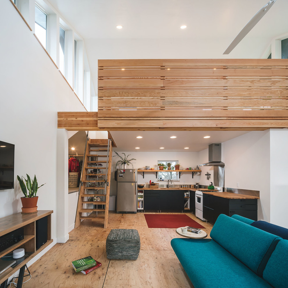 Kleines Modernes Wohnzimmer mit weißer Wandfarbe und Sperrholzboden in Portland