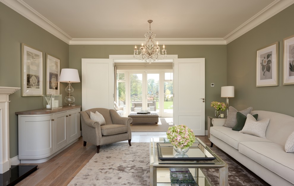 Immagine di un soggiorno tradizionale di medie dimensioni con sala formale, pareti verdi, pavimento in legno massello medio e nessuna TV
