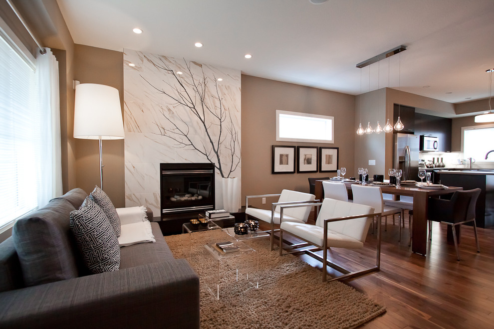 Inspiration for a small contemporary open plan living room in Calgary with brown walls, medium hardwood flooring, a standard fireplace and a tiled fireplace surround.