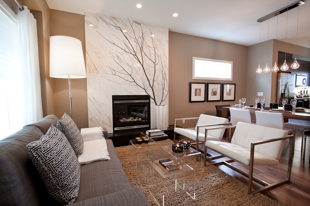 Offenes, Kleines Modernes Wohnzimmer mit Kamin, brauner Wandfarbe, braunem Holzboden und gefliester Kaminumrandung in Calgary