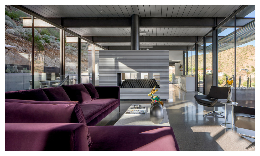 На фото: гостиная комната в стиле модернизм с двусторонним камином и фасадом камина из камня с