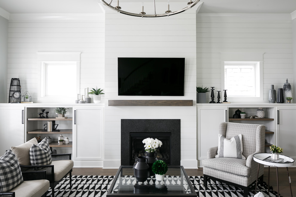 Идея дизайна: гостиная комната в стиле неоклассика (современная классика) с белыми стенами, темным паркетным полом, стандартным камином, телевизором на стене и ковром на полу