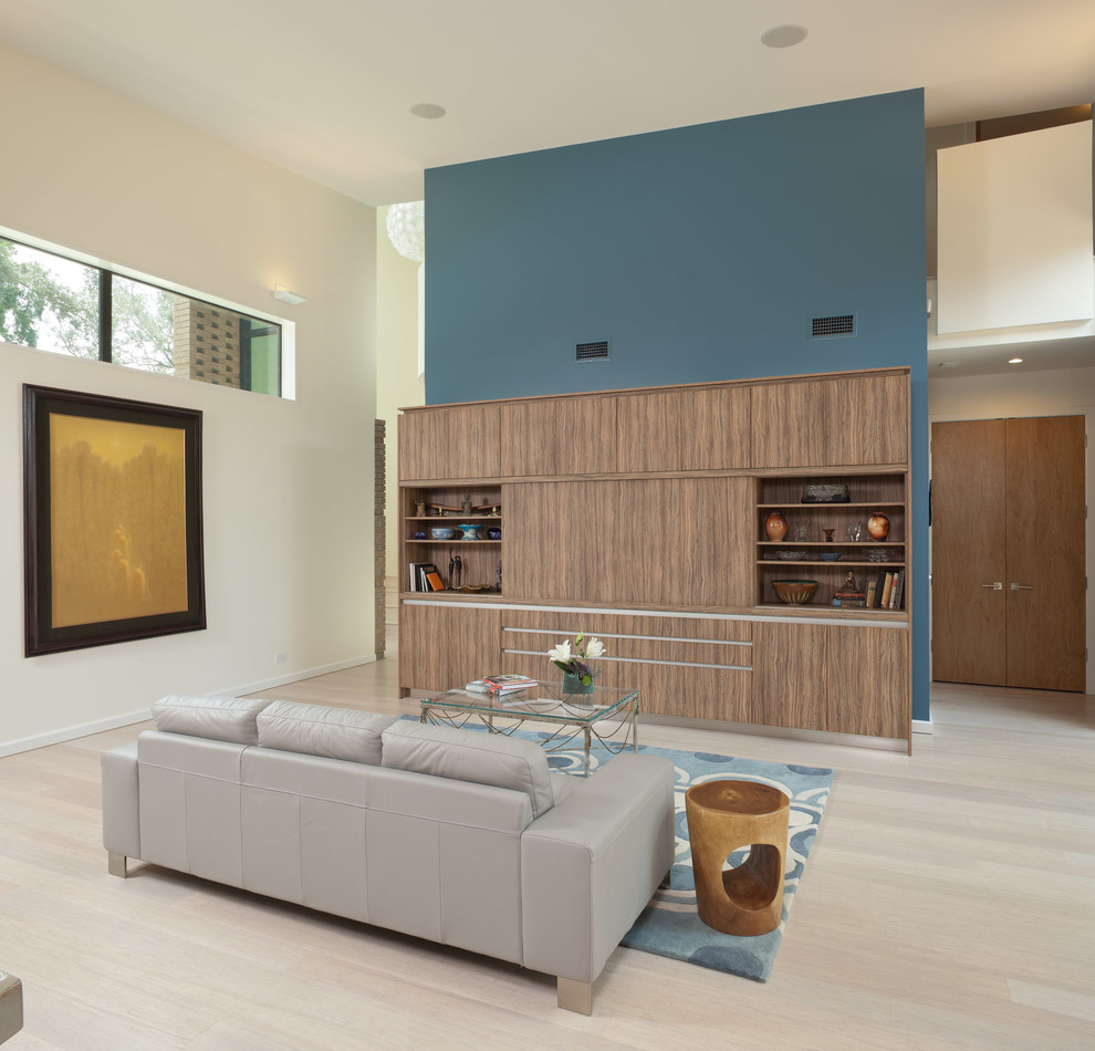 Immagine di un soggiorno design aperto con pareti blu e parquet chiaro