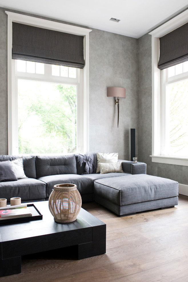 Cette image montre un salon nordique avec un mur gris.
