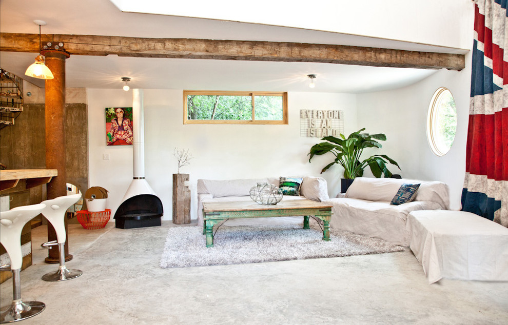 Immagine di un soggiorno eclettico con pavimento in cemento