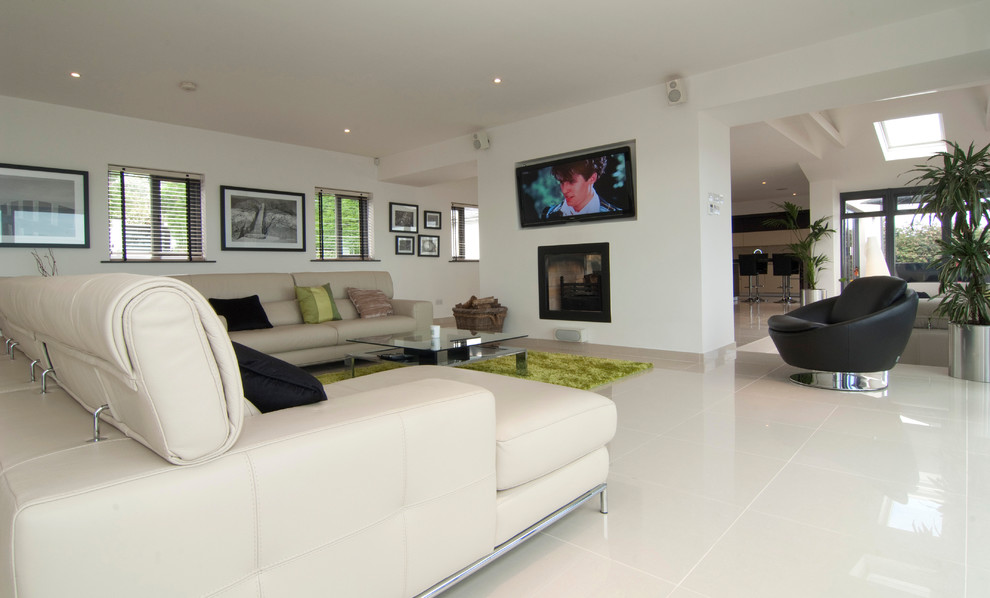 Immagine di un grande soggiorno aperto con sala formale, pareti bianche, pavimento con piastrelle in ceramica, camino bifacciale, TV a parete e pavimento beige