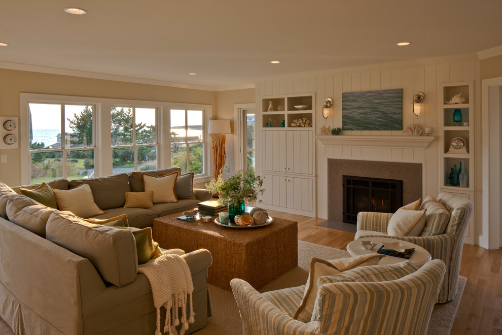Inspiration for a large timeless open concept light wood floor and brown floor living room remodel in Boston with beige walls, a standard fireplace and a concealed tv