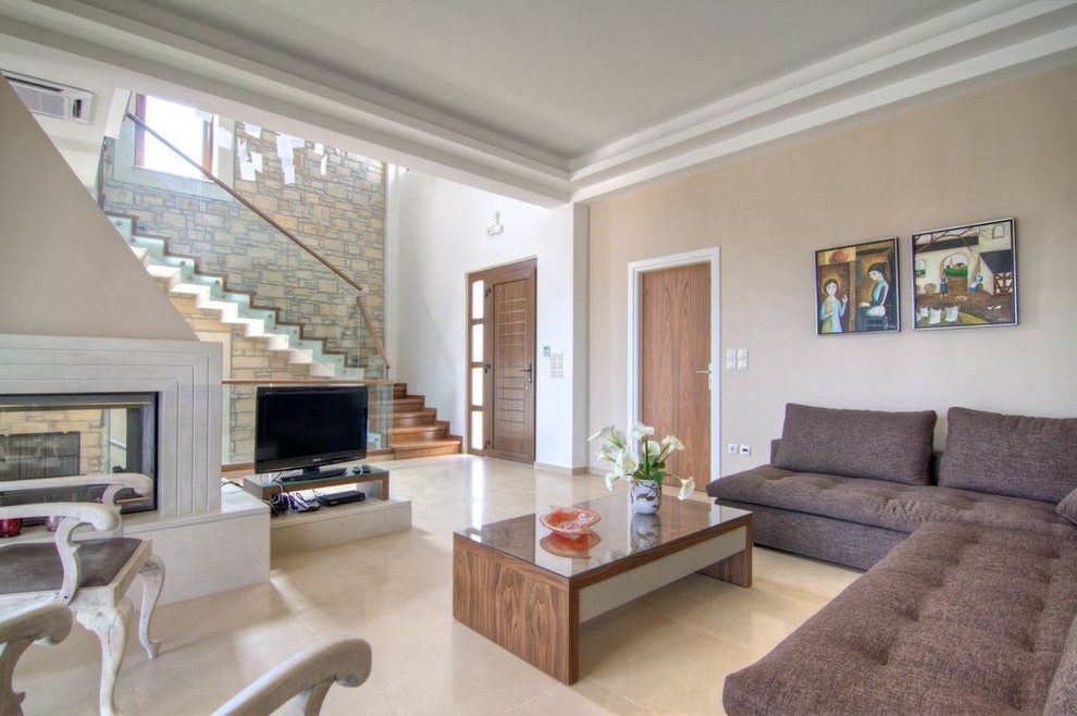 Свежая идея для дизайна: гостиная комната в современном стиле с двусторонним камином и коричневым диваном - отличное фото интерьера