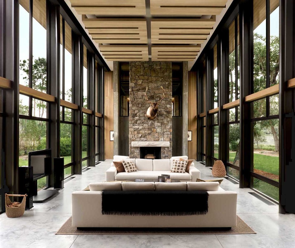 Inspiration for a large contemporary formal enclosed living room in Atlanta with beige walls, concrete flooring, a standard fireplace, a stone fireplace surround and a freestanding tv.