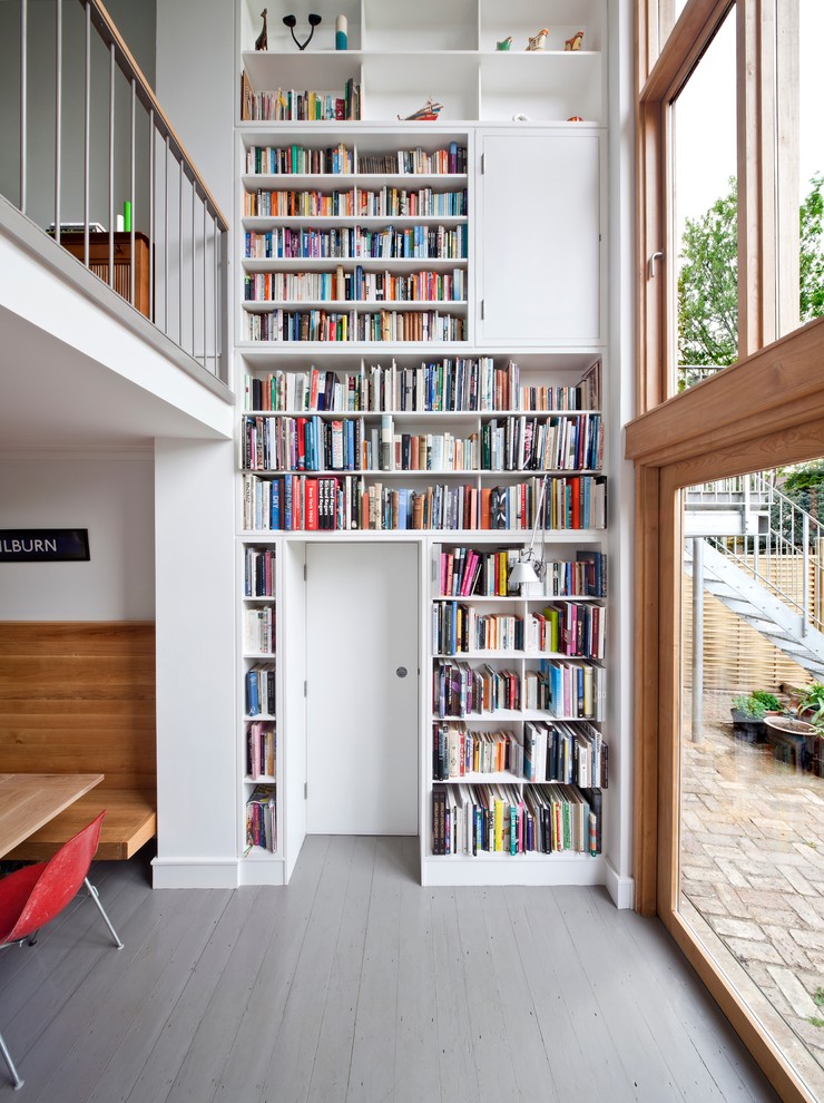 Moderne Bibliothek mit weißer Wandfarbe, gebeiztem Holzboden und grauem Boden in London