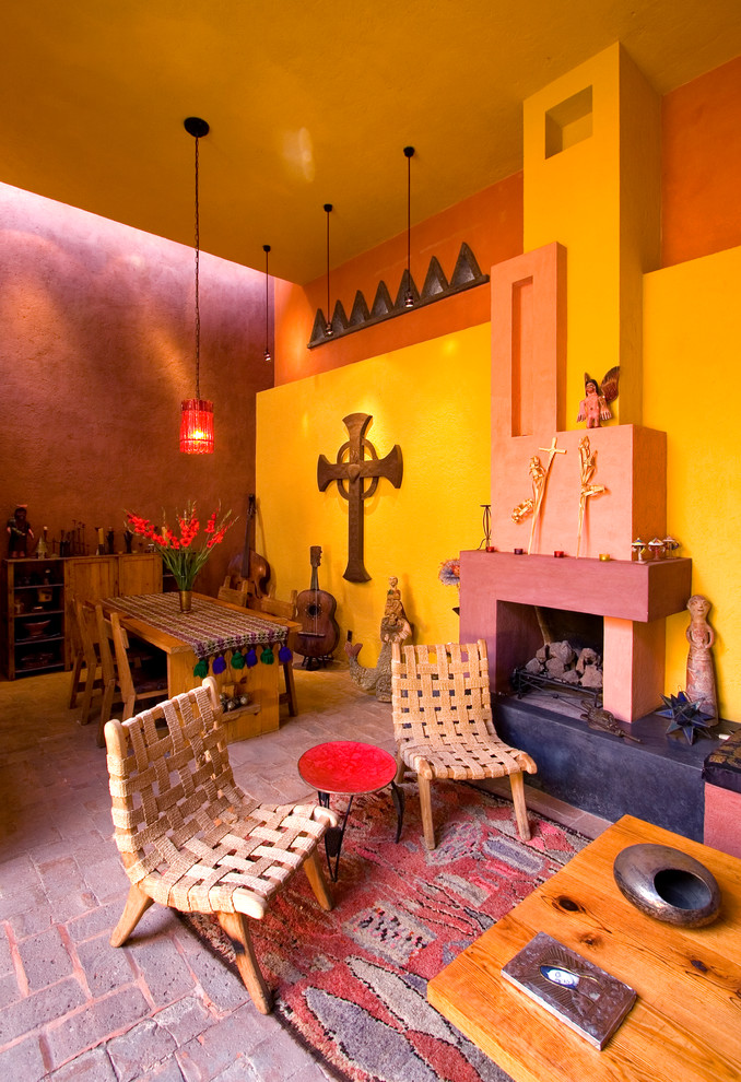 Cette image montre un salon bohème ouvert avec un mur multicolore, un sol en brique, une cheminée standard et un manteau de cheminée en plâtre.
