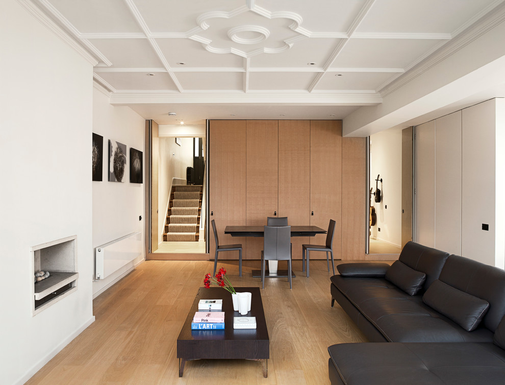 Großes, Repräsentatives, Fernseherloses, Offenes Modernes Wohnzimmer mit weißer Wandfarbe, hellem Holzboden, Kamin und Kaminumrandung aus Stein in London