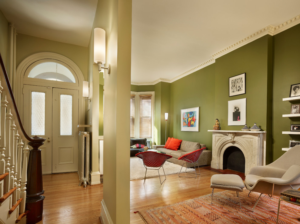 Пример оригинального дизайна: открытая гостиная комната среднего размера в стиле неоклассика (современная классика) с зелеными стенами, паркетным полом среднего тона, горизонтальным камином, фасадом камина из камня и телевизором на стене