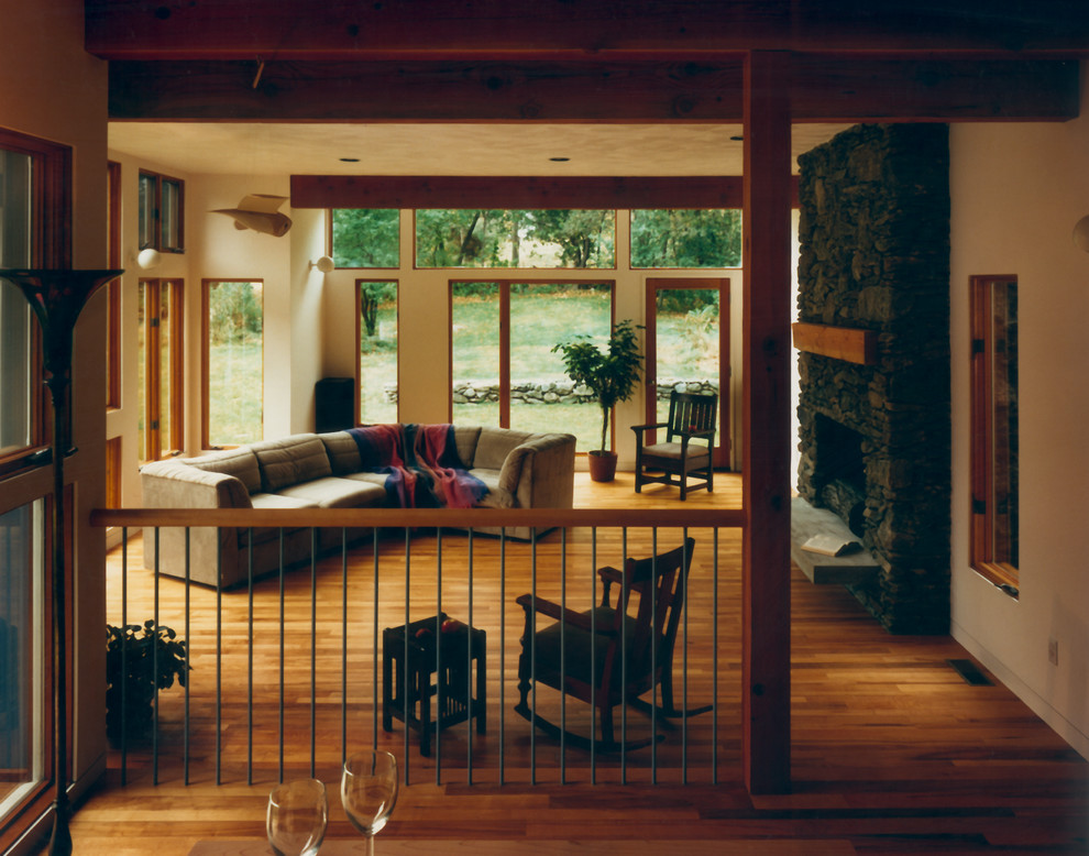 Exempel på ett mellanstort modernt separat vardagsrum, med ett finrum, beige väggar, mellanmörkt trägolv, en standard öppen spis och en spiselkrans i sten