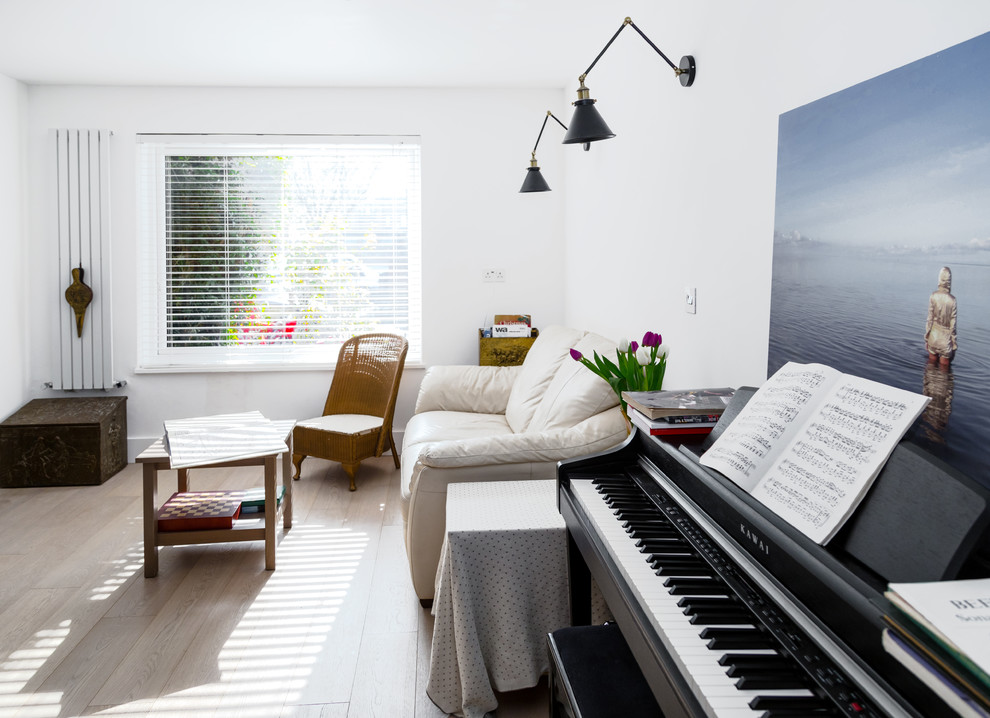 Foto på ett mellanstort funkis allrum med öppen planlösning, med vita väggar, ljust trägolv, en fristående TV och vitt golv