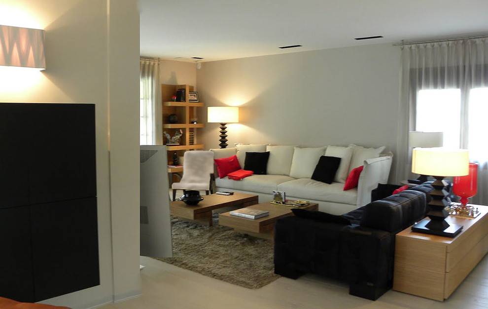 Ejemplo de salón para visitas abierto moderno de tamaño medio sin chimenea con paredes beige, suelo de madera clara y televisor independiente