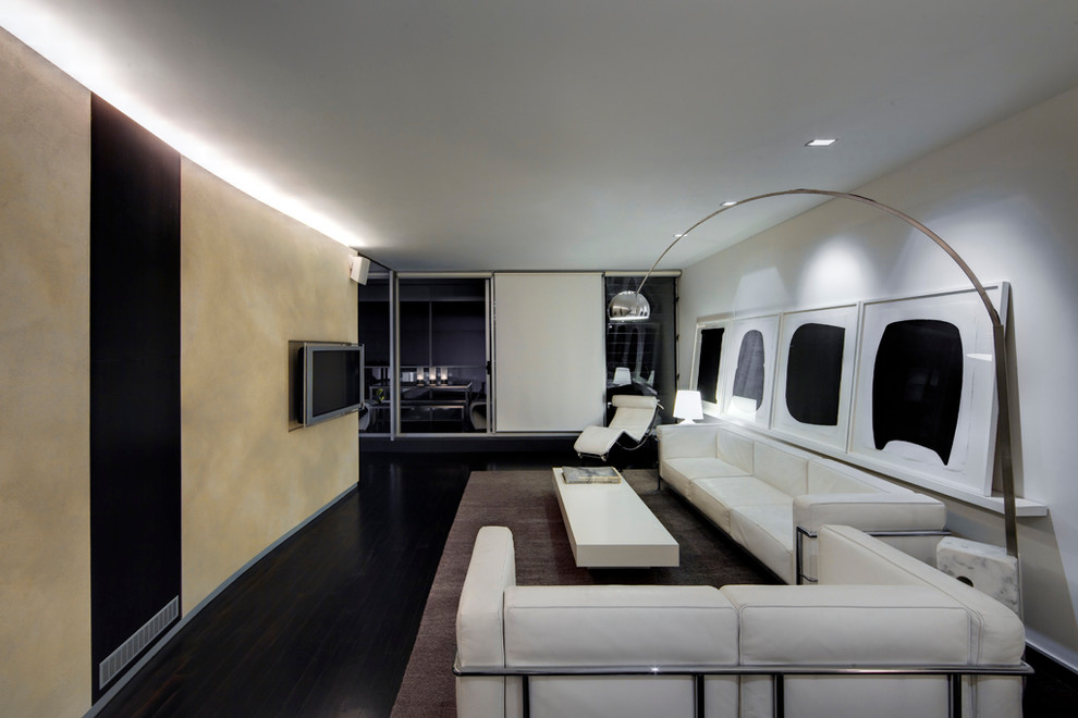 Esempio di un soggiorno minimalista di medie dimensioni con sala formale, parquet scuro e TV a parete
