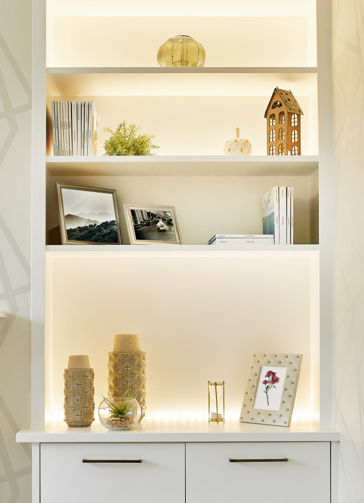 Cette image montre un petit salon minimaliste avec une bibliothèque ou un coin lecture, un mur blanc, un sol en bois brun, une cheminée standard, un manteau de cheminée en carrelage, un téléviseur encastré, un sol marron et du papier peint.