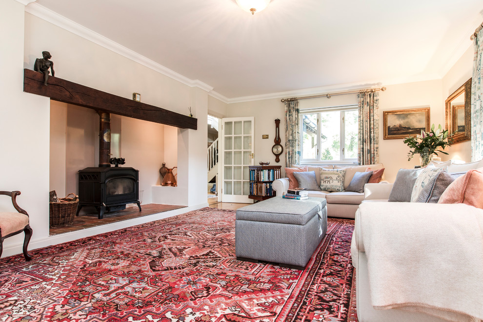 Großes, Repräsentatives, Offenes Klassisches Wohnzimmer mit braunem Holzboden, Kaminofen, verputzter Kaminumrandung, beiger Wandfarbe und freistehendem TV in Hampshire