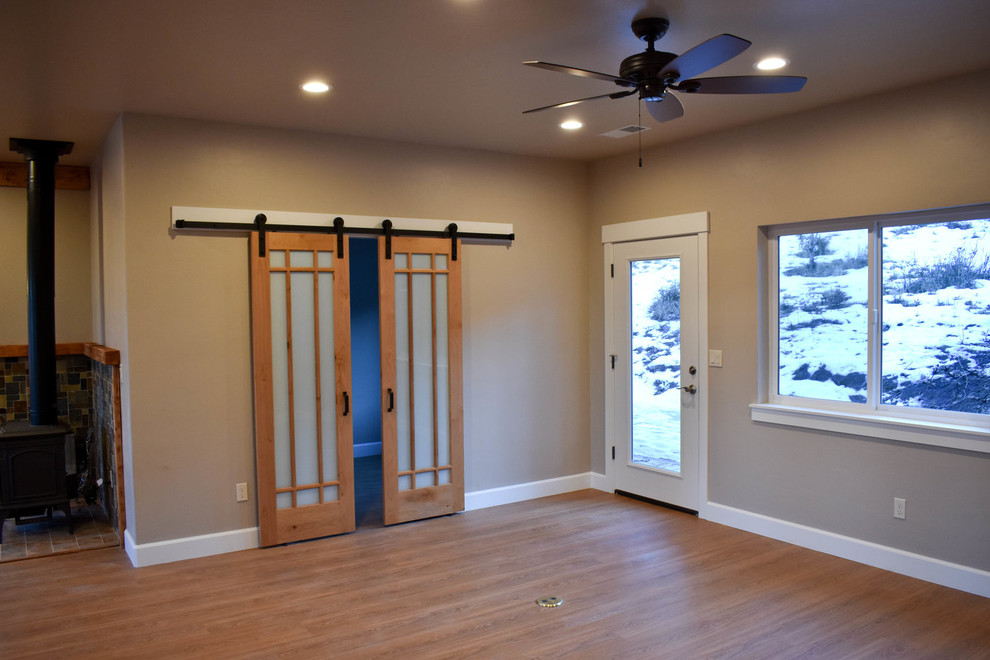 Immagine di un soggiorno stile rurale di medie dimensioni e chiuso con pareti beige, pavimento in legno massello medio, stufa a legna e pavimento marrone