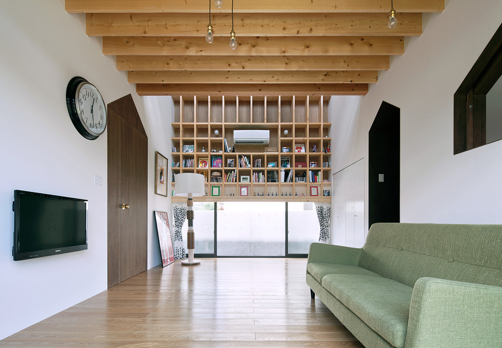 Esempio di un soggiorno minimal con pareti bianche, TV a parete e pavimento marrone