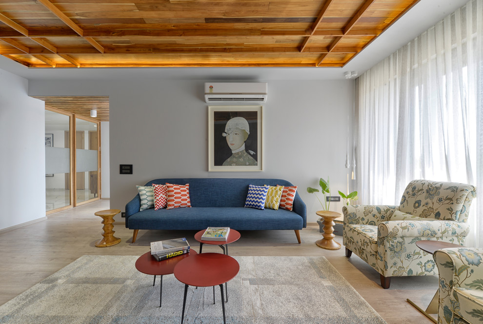 Modernes Wohnzimmer mit grauer Wandfarbe, hellem Holzboden und braunem Boden in Ahmedabad