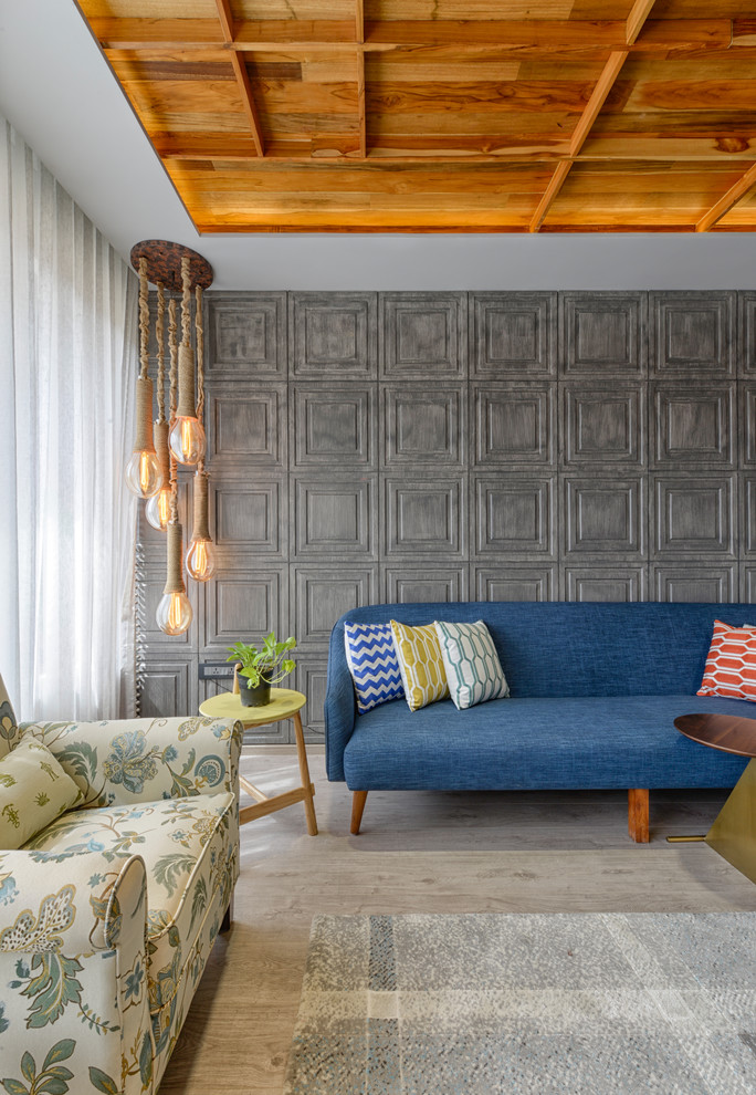 Modernes Wohnzimmer mit grauer Wandfarbe, hellem Holzboden und braunem Boden in Ahmedabad