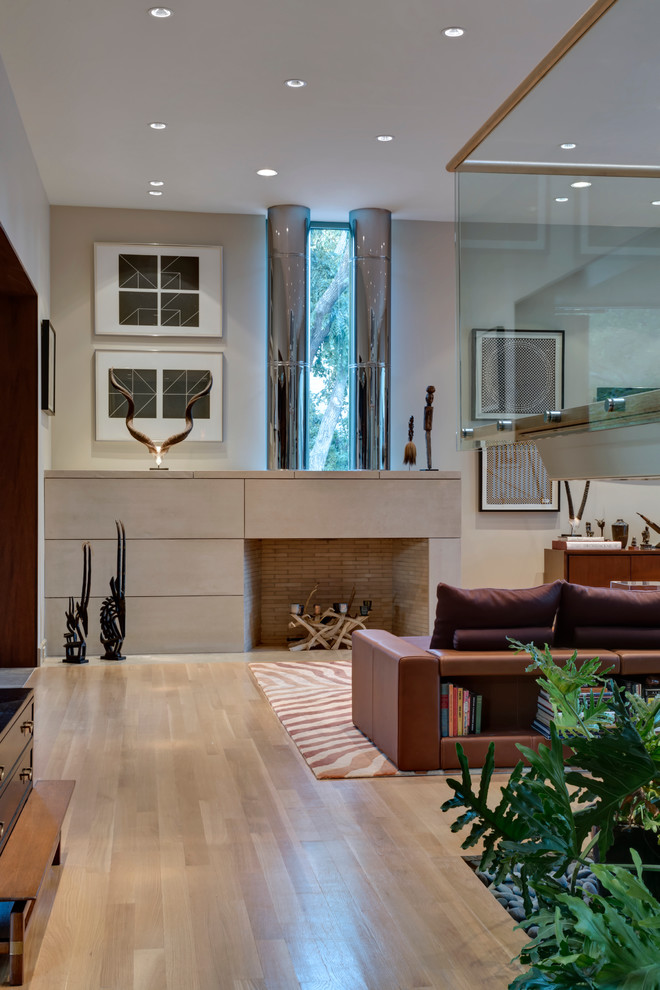 Großes, Offenes Modernes Wohnzimmer mit beiger Wandfarbe, hellem Holzboden und Kaminumrandung aus Stein in Dallas