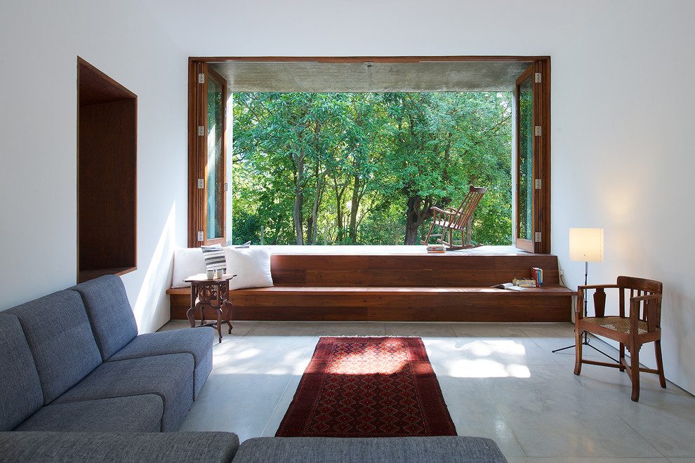 Example of a mid-sized minimalist open concept and formal living room design in Mumbai with white walls