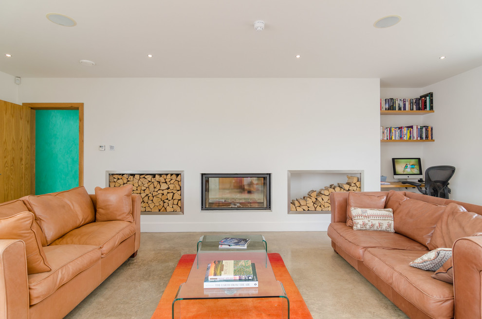This is an example of a contemporary living room in Belfast with a reading nook, white walls and a two-sided fireplace.