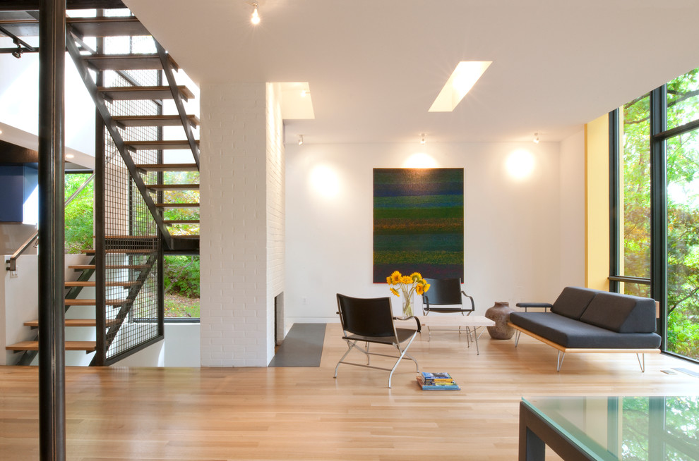 Стильный дизайн: гостиная комната в стиле модернизм с белыми стенами, стандартным камином и фасадом камина из кирпича без телевизора - последний тренд