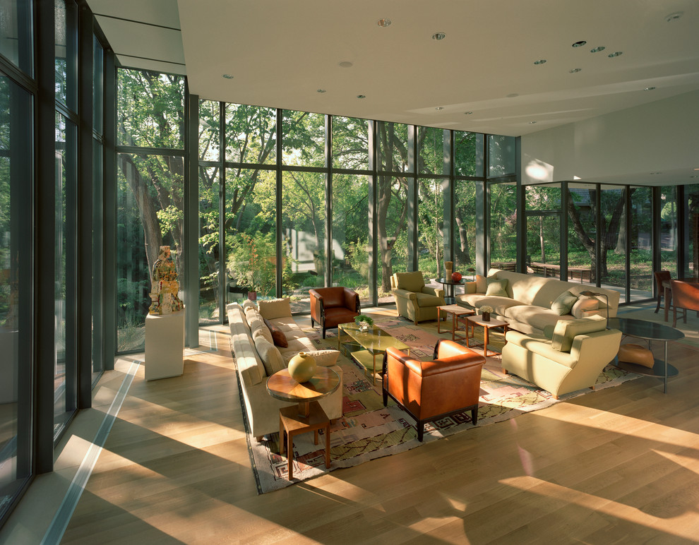 Immagine di un soggiorno moderno aperto con parquet chiaro