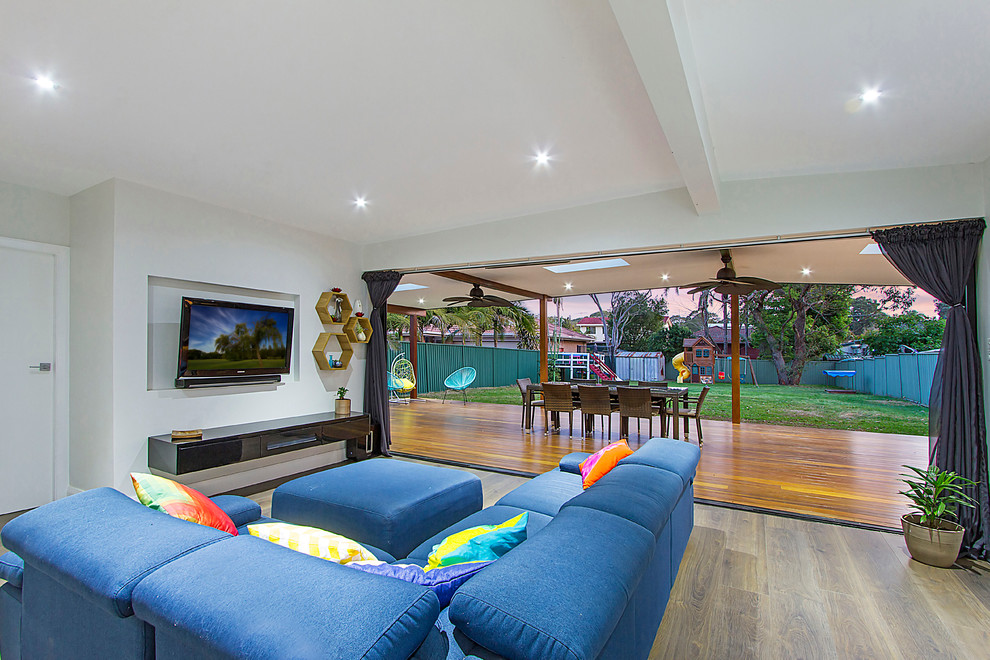 Großes, Repräsentatives, Offenes Modernes Wohnzimmer ohne Kamin mit grauer Wandfarbe, hellem Holzboden und TV-Wand in Sydney