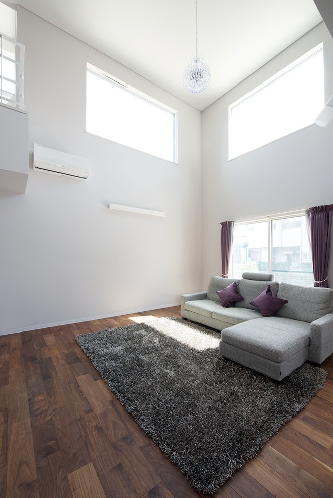 Exemple d'un salon moderne ouvert avec un mur gris, parquet foncé et un téléviseur indépendant.