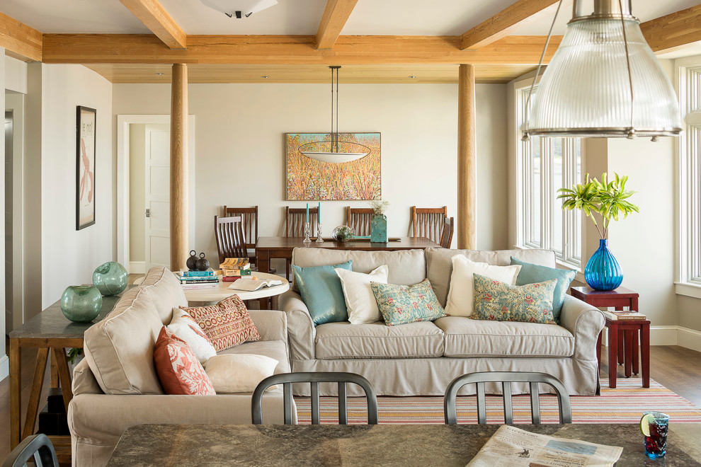 Ejemplo de salón abierto y blanco y madera costero con paredes beige, suelo de madera en tonos medios, vigas vistas y alfombra