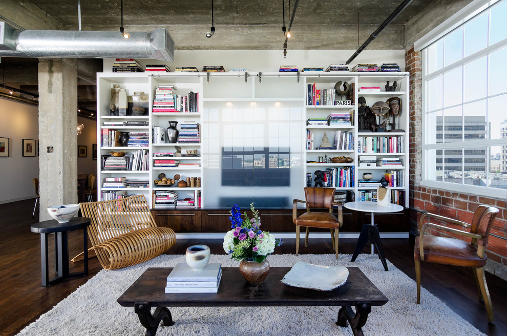 Inspiration for an industrial living room library remodel in Houston with a concealed tv