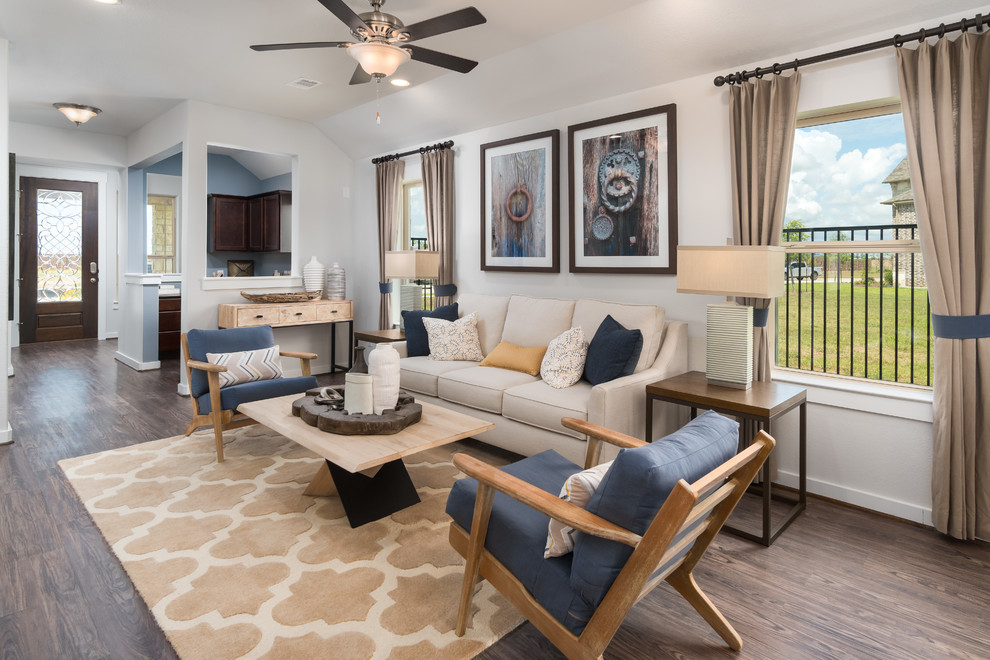 Immagine di un soggiorno minimal di medie dimensioni e aperto con pareti beige, pavimento in laminato e pavimento marrone