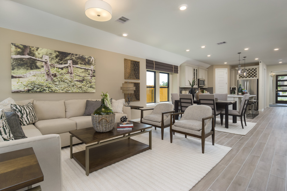 Mittelgroßes, Offenes Modernes Wohnzimmer mit beiger Wandfarbe, hellem Holzboden, TV-Wand und beigem Boden in Houston