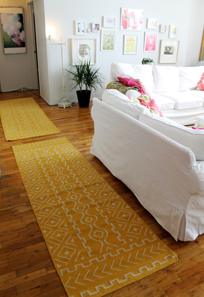 Ispirazione per un soggiorno bohémian aperto con pareti bianche, pavimento in legno massello medio e TV autoportante