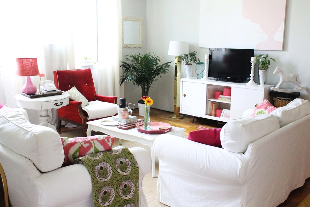 Idee per un soggiorno boho chic aperto con pareti bianche, pavimento in legno massello medio e TV autoportante